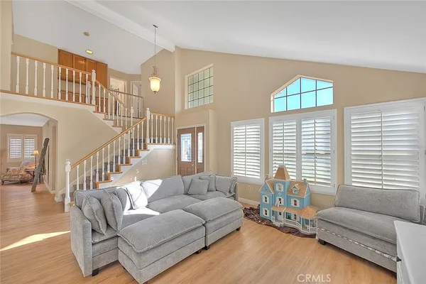 a living room with furniture and two large windows
