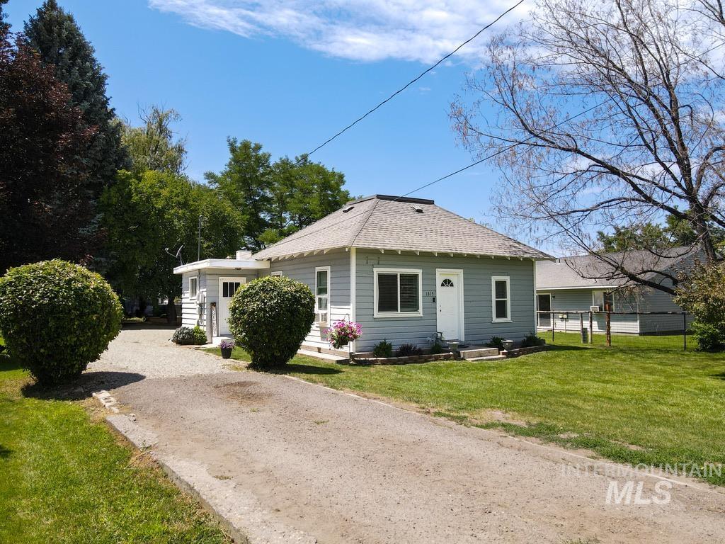 Bungalow-style home with roof with shingles and driveway