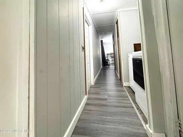 a hallway with wooden floor and staircase