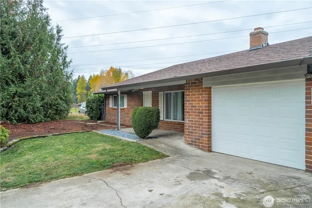 a view of a house with a yard and large tree