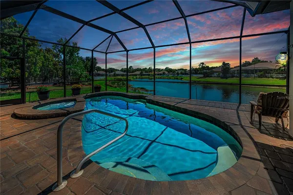 a view of swimming pool from a patio with a yard