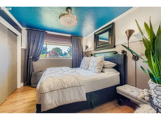 a bedroom with a bed window and a potted plant