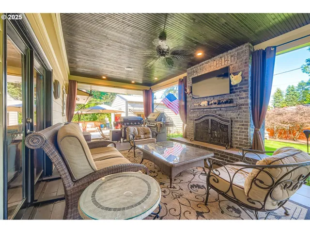a living room with furniture a fireplace and a floor to ceiling window