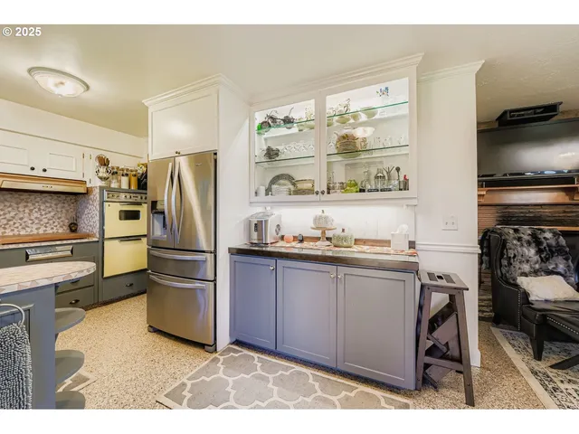 a kitchen with granite countertop a refrigerator and a stove top oven