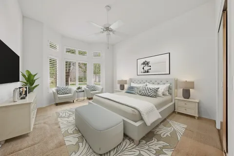 a spacious bedroom with a bed a couch and a potted plant