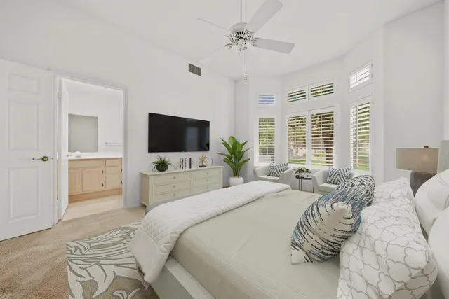 a bedroom with a bed tv and a window