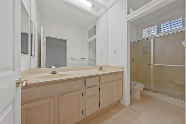 a bathroom with a double vanity sink toilet and shower