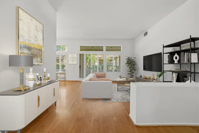 a living room with furniture a flat screen tv and a large window