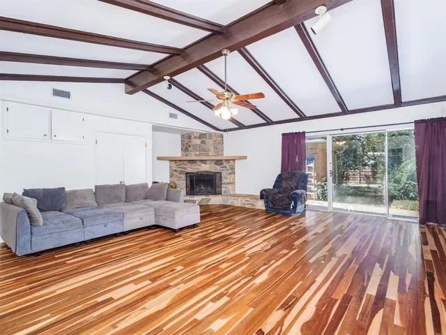 a living room with furniture a fireplace and wooden floor