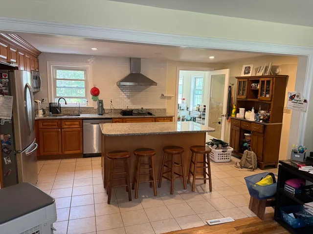a kitchen with stainless steel appliances granite countertop a sink and a refrigerator