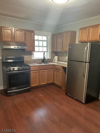 a kitchen with sink a microwave a refrigerator and cabinets