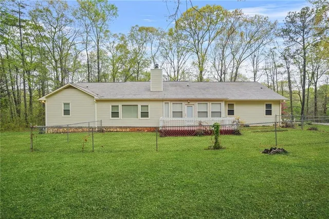 a view of house with a backyard and a tree