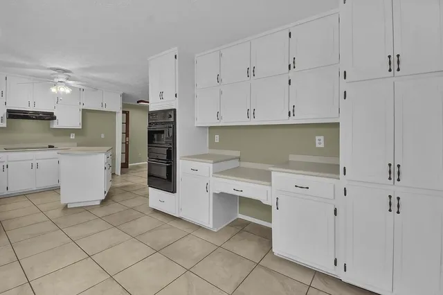 a kitchen with white cabinets and white appliances