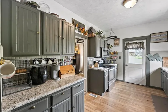a kitchen with stainless steel appliances granite countertop a stove a sink and a refrigerator
