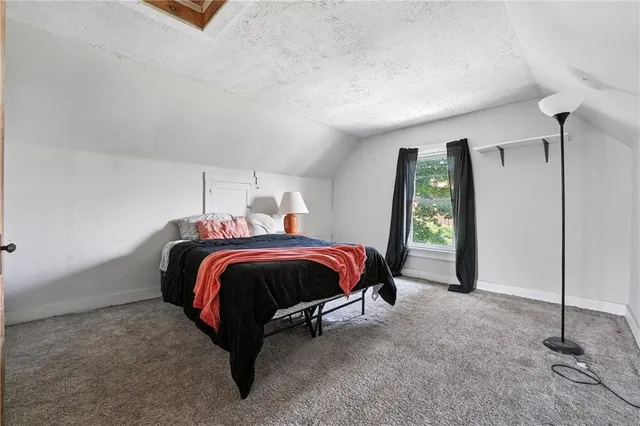 a spacious bedroom with a bed and large window