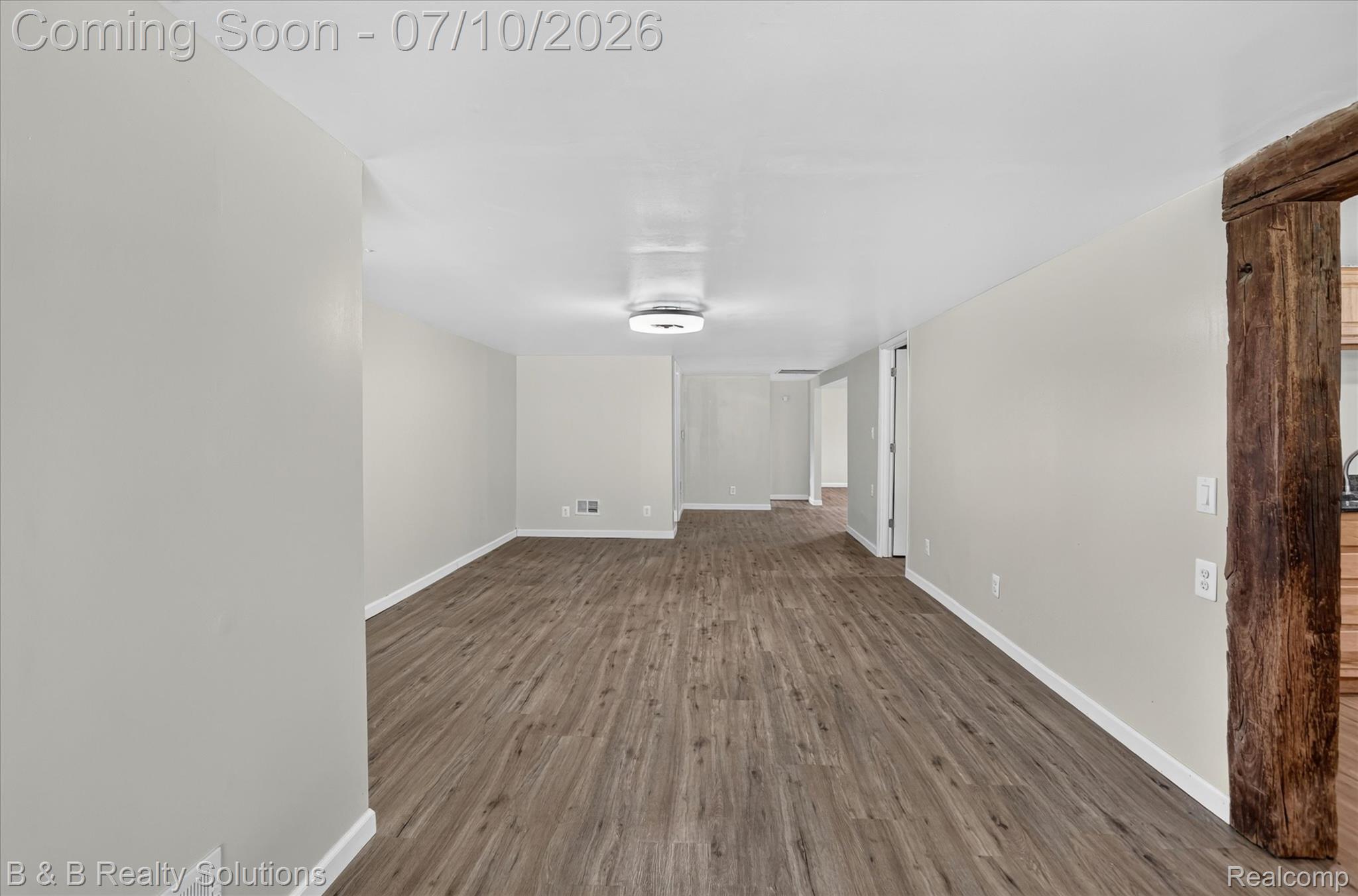 1564 East Burnside Road North Branch, MI 48461 - Photo 9 of 25 Open-concept room featuring wood-finish flooring, light gray walls, and white trim