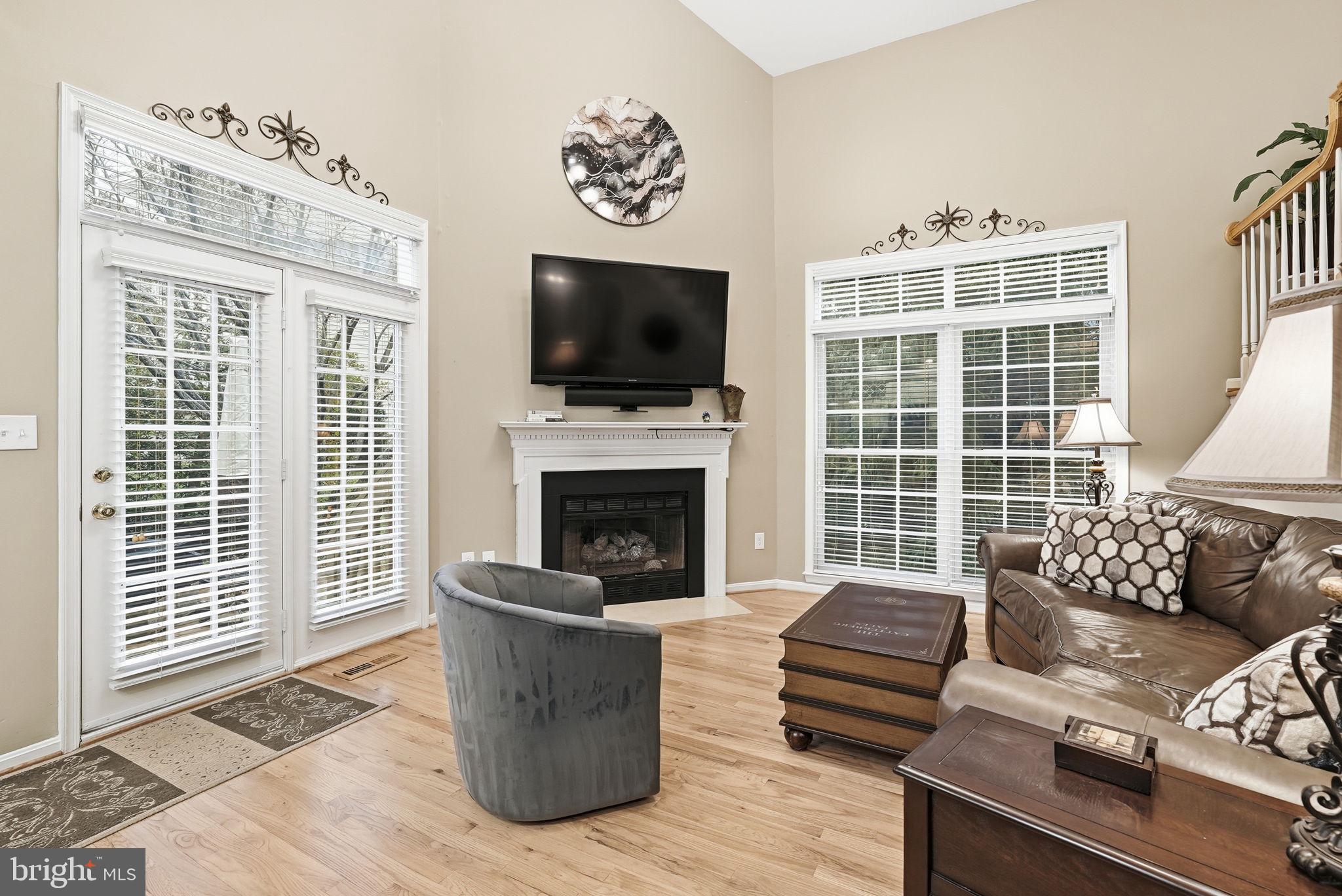 11411 Hollow Timber Court Reston, VA 20194 - Photo 13 of 46 a living room with furniture a flat screen tv and a fireplace