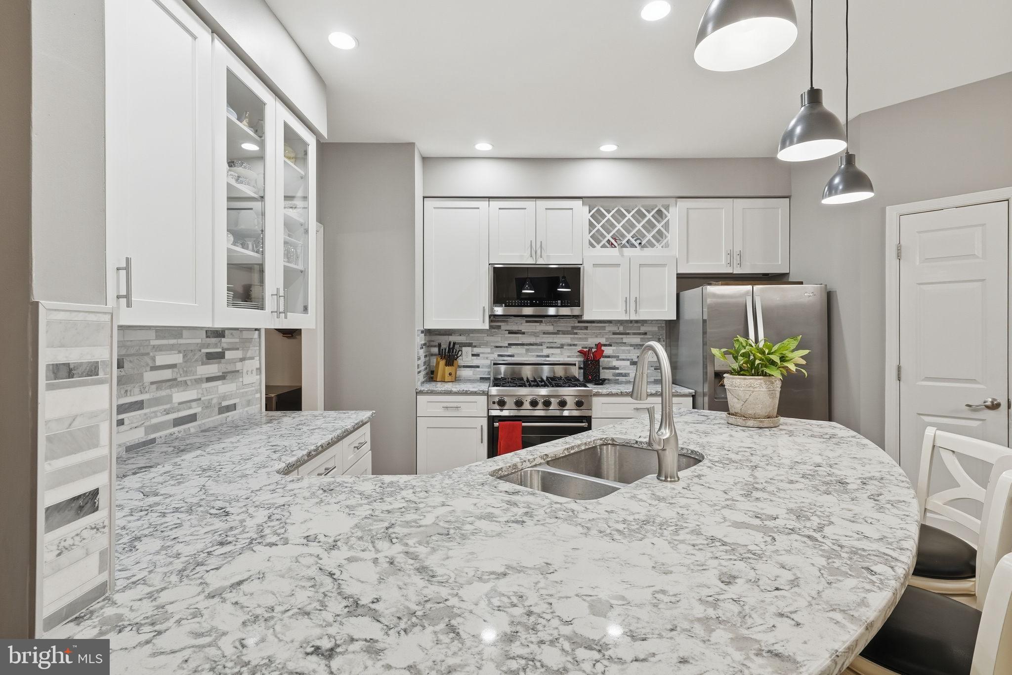 11411 Hollow Timber Court Reston, VA 20194 - Photo 16 of 46 a kitchen with stainless steel appliances kitchen island granite countertop a stove sink and cabinets