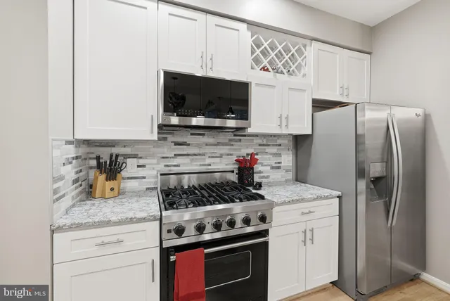 a kitchen with stainless steel appliances granite countertop a refrigerator stove and microwave