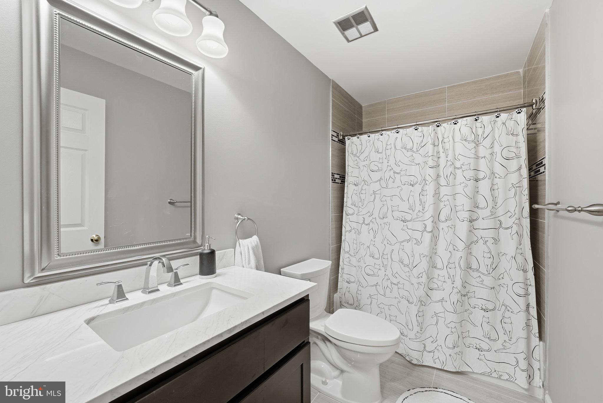 11411 Hollow Timber Court Reston, VA 20194 - Photo 31 of 46 a bathroom with a sink a toilet a mirror and shower curtain