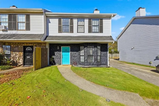 a view of a house with a yard and a garage