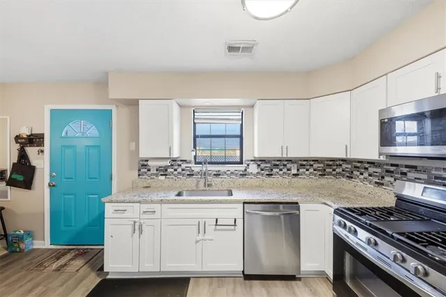 a kitchen with white cabinets and appliances