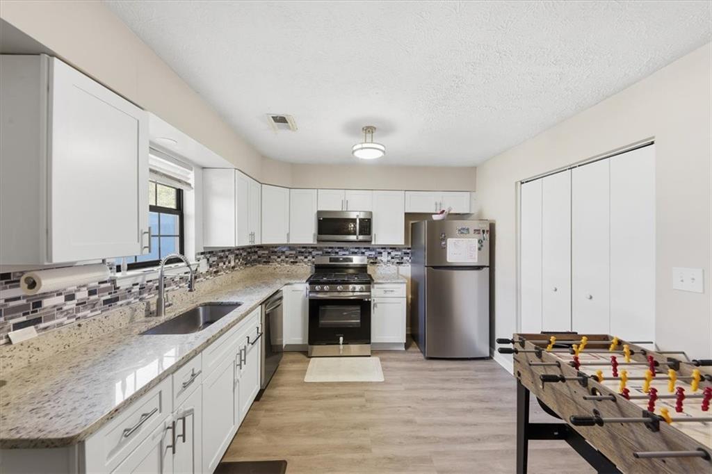 3682 Stephanie Court Powder Springs, GA 30127 - Photo 13 of 23 a large kitchen with a stove a refrigerator and a sink