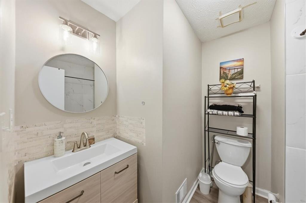 3682 Stephanie Court Powder Springs, GA 30127 - Photo 19 of 23 a bathroom with a toilet a sink and mirror