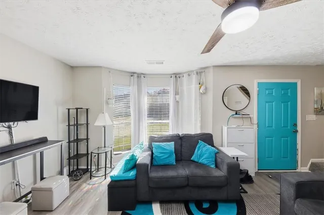 a living room with furniture a flat screen tv and a large window