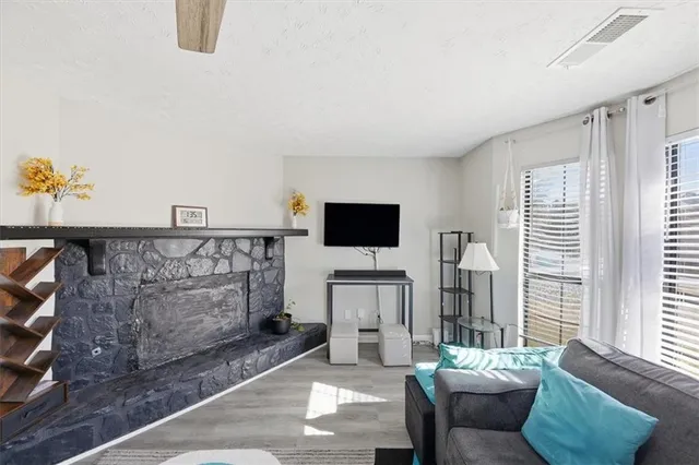 a living room with furniture a flat screen tv and a window