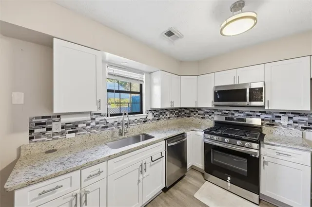 a kitchen with stainless steel appliances a stove sink and microwave
