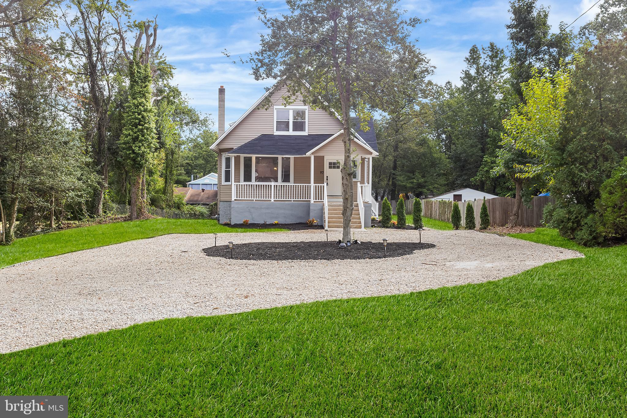 a front view of a house with a yard and trees