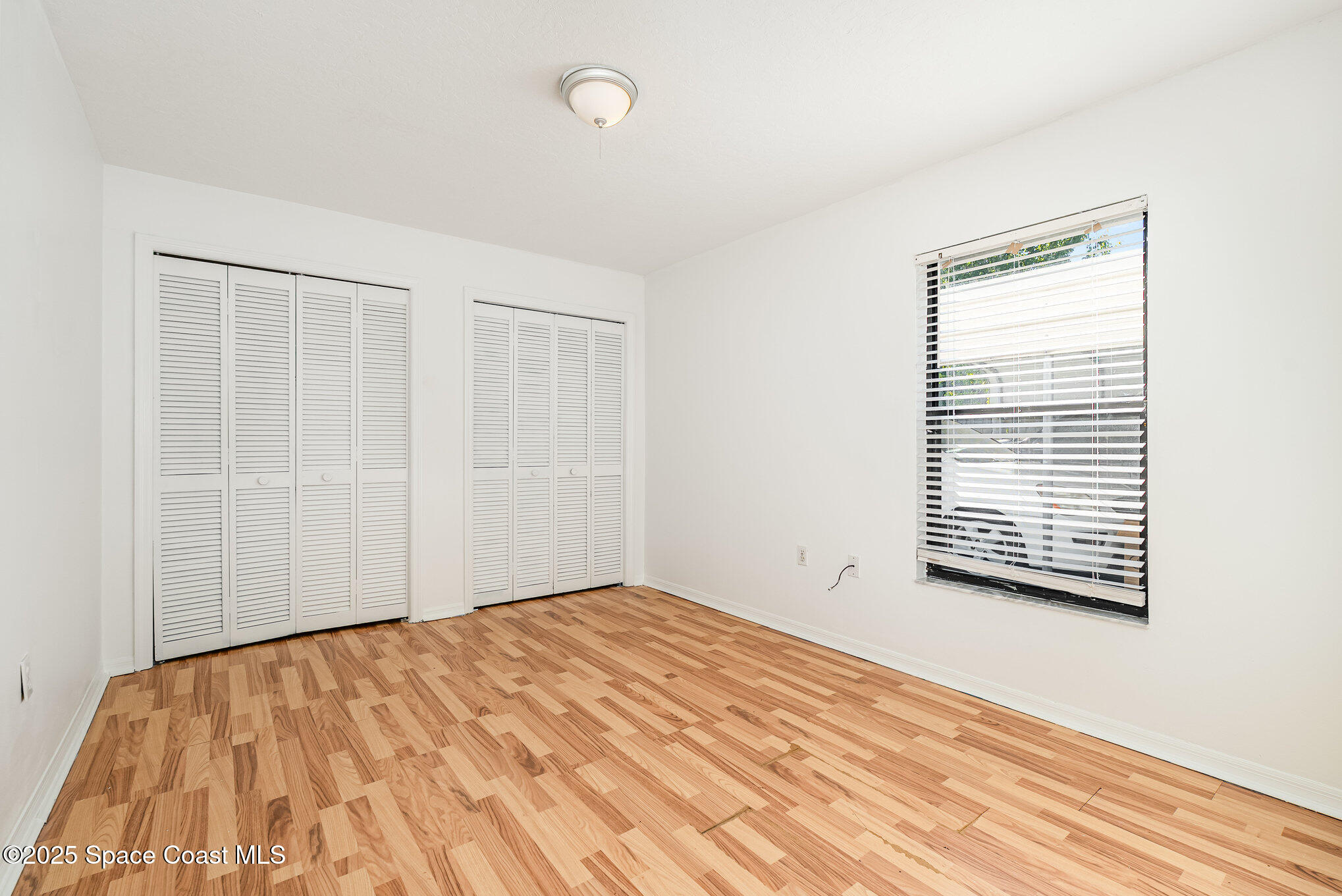5720 Flint Road Cocoa, FL 32927 - Photo 13 of 26 a view of an empty room with wooden floor and a window
