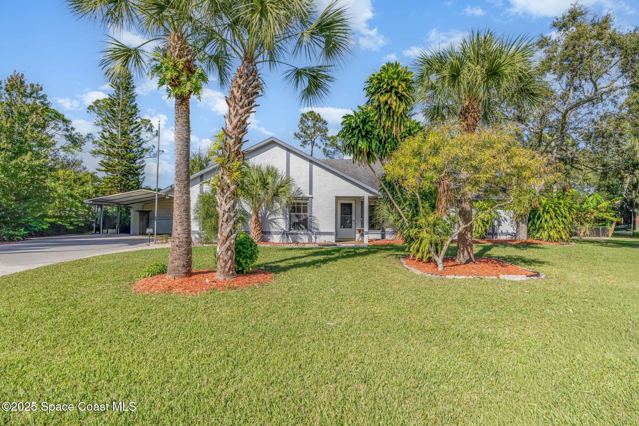 5720 Flint Road Cocoa, FL 32927 - Photo 2 of 26 a house with lots of trees in front of it