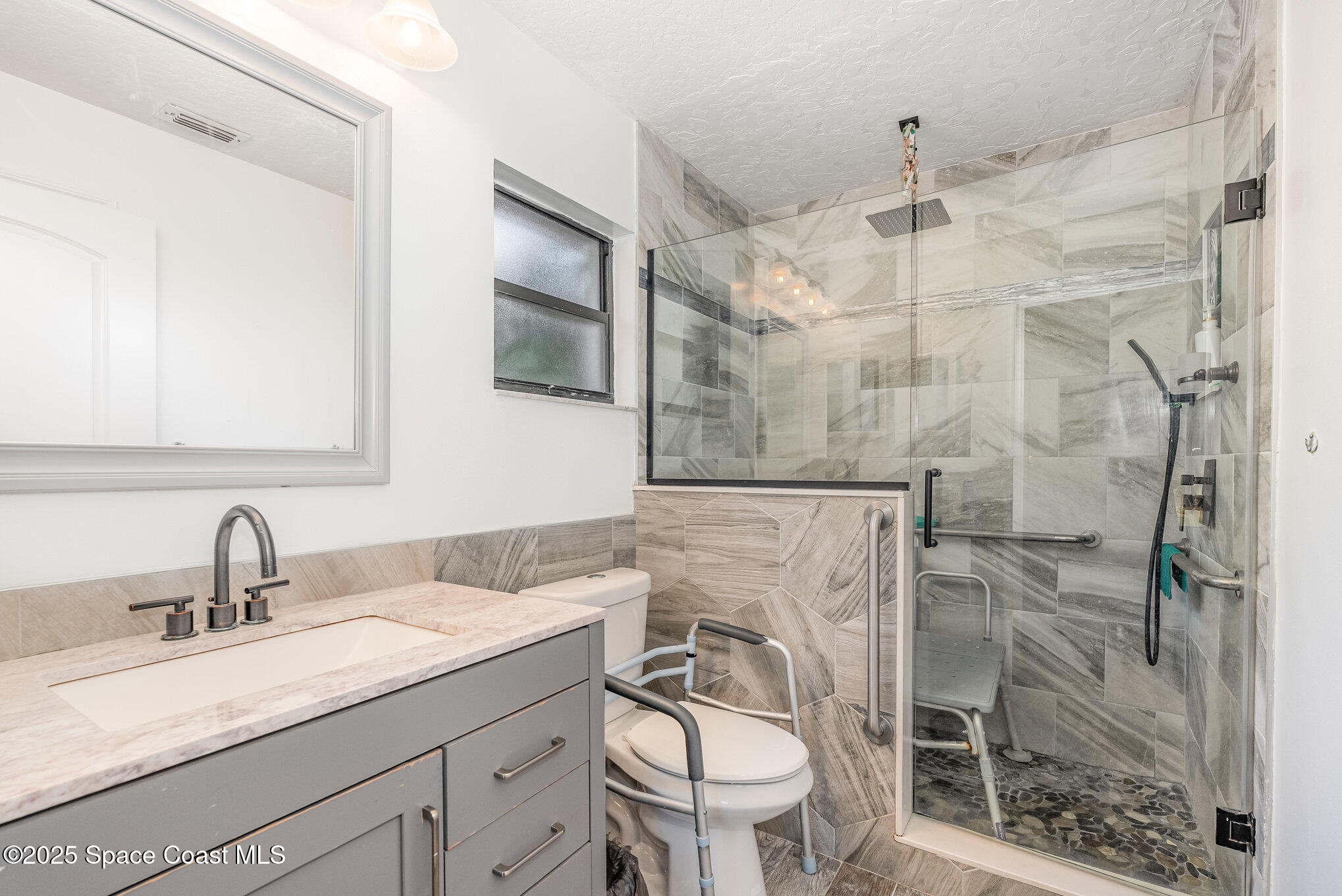 5720 Flint Road Cocoa, FL 32927 - Photo 5 of 26 a bathroom with a granite countertop sink a mirror and shower