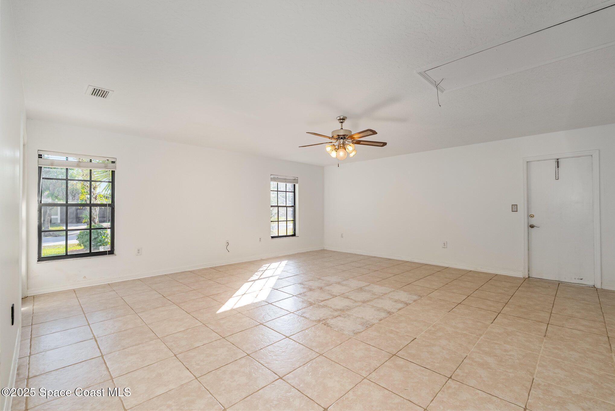 5720 Flint Road Cocoa, FL 32927 - Photo 8 of 26 a view of an empty room with window and chandelier fan