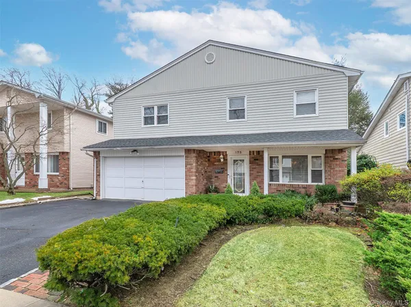 a front view of a house with a garden and plants