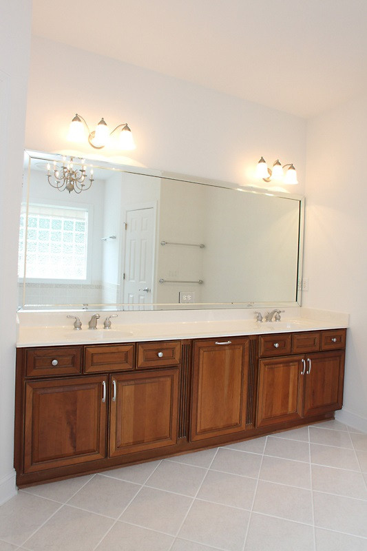 11612 Midlavian Drive Raleigh, NC 27614 - Photo 13 of 25 The master bath features neutral tile, long vanity and a chandelier! There is even a clothes hamper in the vanity! Pristinely kept! Master Bath/Spa