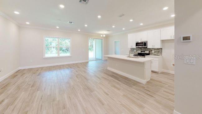 Tbd Mohawk Road Venice, FL 34293 - Photo 5 of 16 a kitchen with stainless steel appliances a microwave a stove a sink and white cabinets with wooden floor
