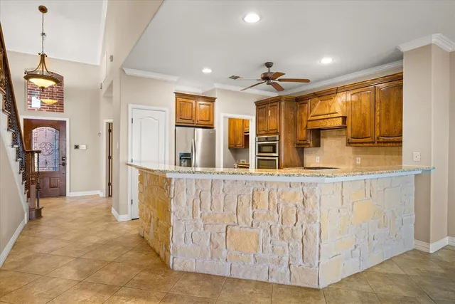 a view of a kitchen with stainless steel appliances granite countertop a refrigerator and a stove top oven