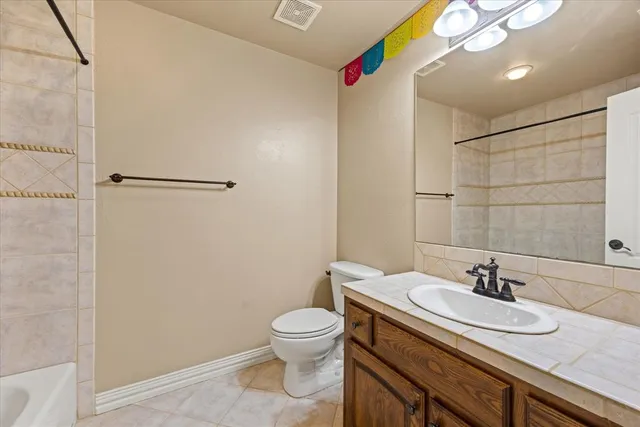 a bathroom with a granite countertop sink a toilet and a mirror