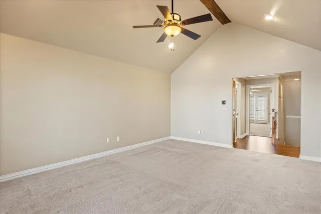 an empty room with a fan & a ceiling fan
