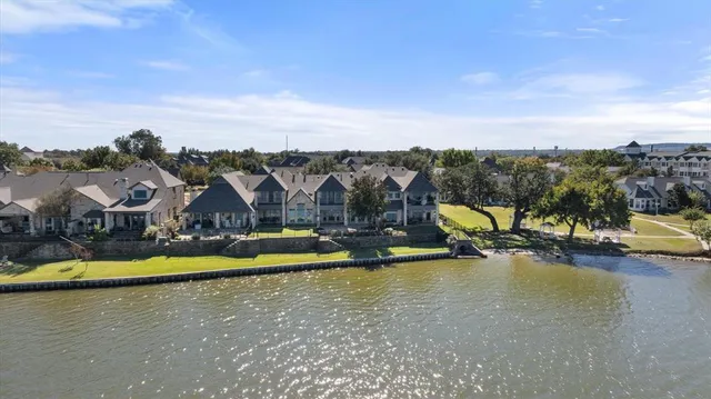 an aerial view of a house with swimming pool and lake view