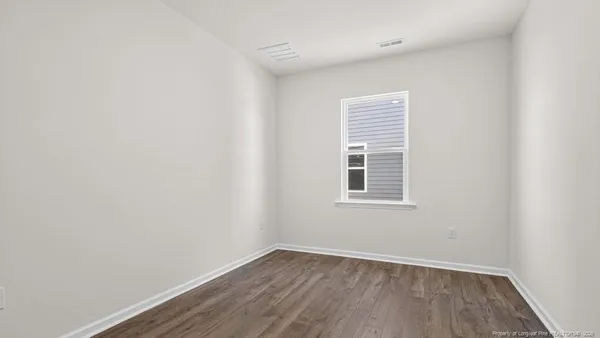 an empty room with wooden floor and a window