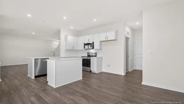 a kitchen with a refrigerator and a stove top oven