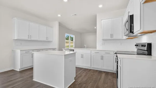 a kitchen with cabinets appliances a sink and a counter top space