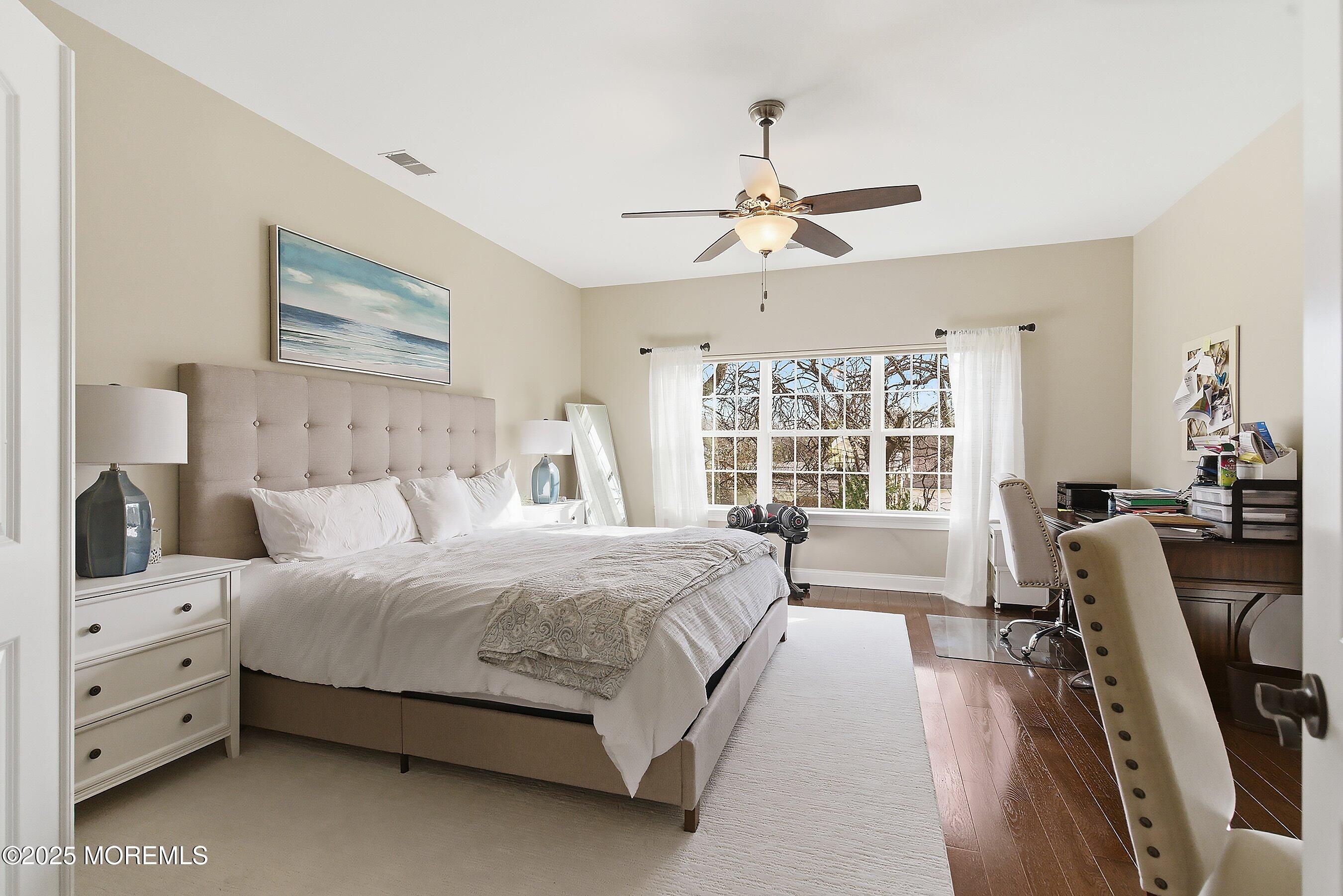 24 Abbey Road Tinton Falls, NJ 07753 - Photo 34 of 52 a bedroom with a large bed and a chandelier