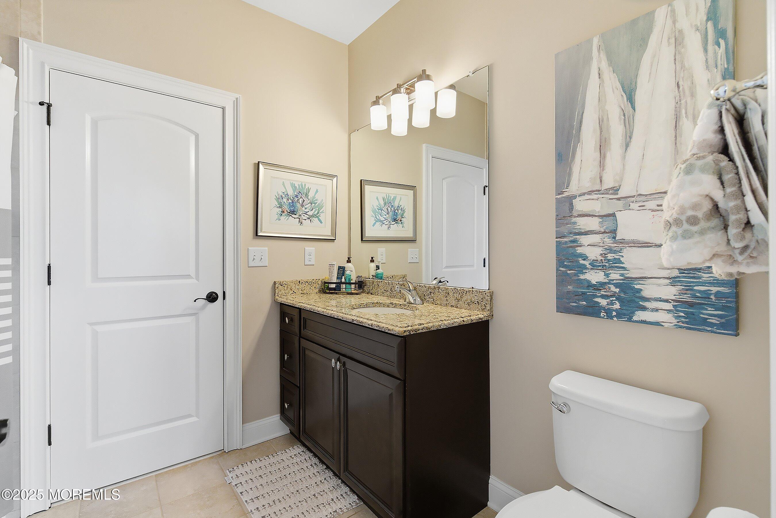 24 Abbey Road Tinton Falls, NJ 07753 - Photo 38 of 52 a bathroom with a toilet sink and mirror
