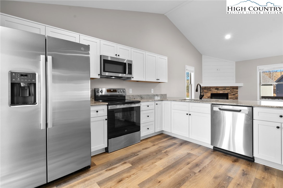 233 Ava Way, Unit 109 Boone, NC 28607 - Photo 11 of 26 a kitchen with white cabinets stainless steel appliances and a refrigerator