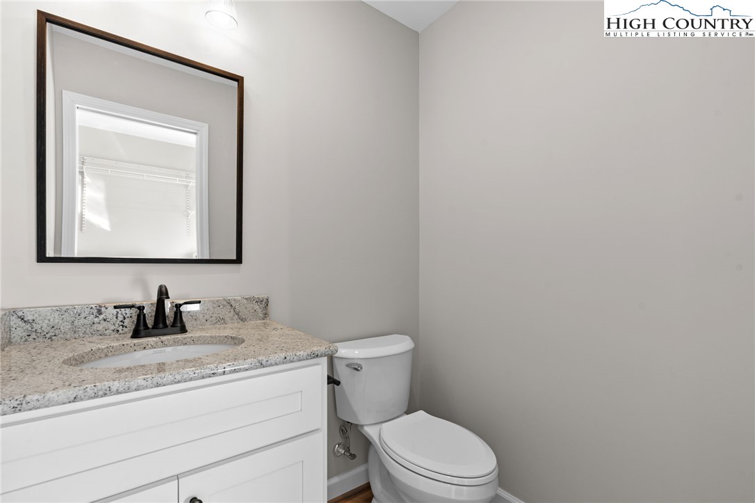 233 Ava Way, Unit 109 Boone, NC 28607 - Photo 23 of 26 a bathroom with a toilet sink vanity and mirror